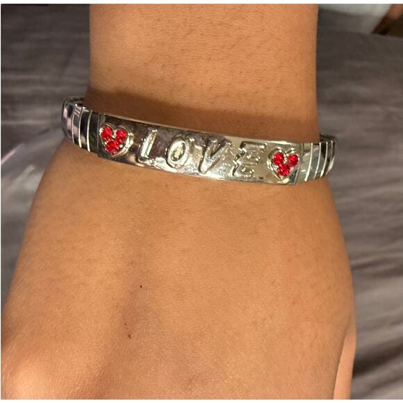 STAINLESS SILVER TONE CUFF BRACELET WITH THE WORD LOVE & TWO RED CRYSTAL HEARTS